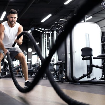 Mann trainiert mit Seilen im Fitnessstudio