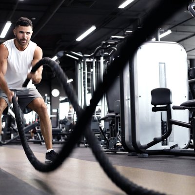 Mann trainiert mit Seilen im Fitnessstudio